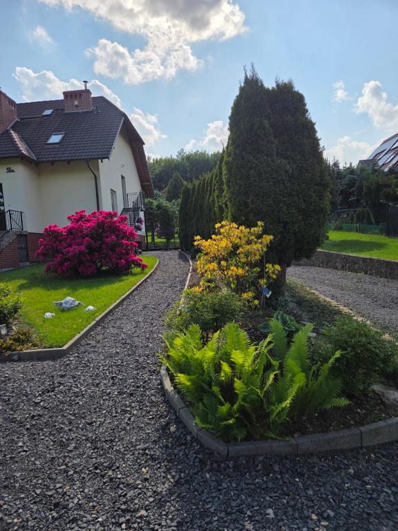 a garden with flowers and plants in front of a house at Zatrzymaj Się in Stronie Śląskie
