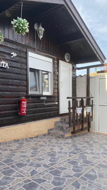 a house with a porch with a bench on a patio at Cottage in Ciudad Quesada in Ciudad Quesada
