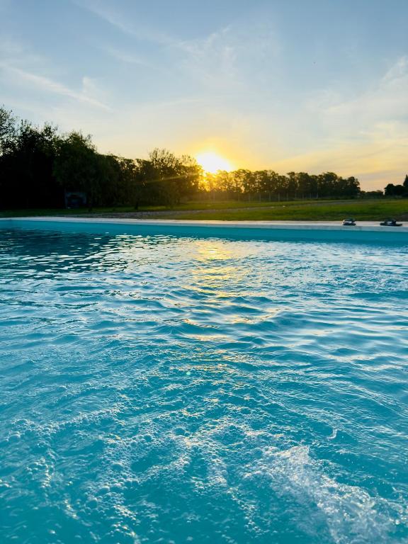 a view of a body of water with the sun setting at Cabaña en cañuelas in Cañuelas