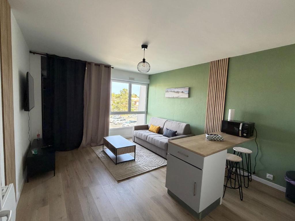 a living room with a couch and a table at Studio côté soleil in Saint-Jean-de-Monts