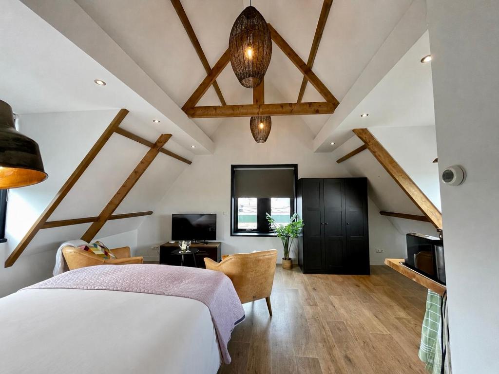 a bedroom with a king sized bed and a tv at Room at the Beach Egmond in Egmond aan Zee