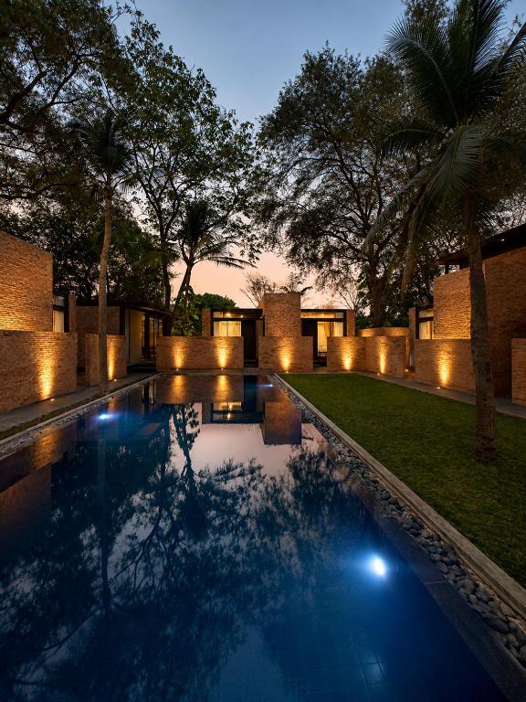 a swimming pool with lights in a backyard at night at Makham Villa River Kwai in Kanchanaburi City