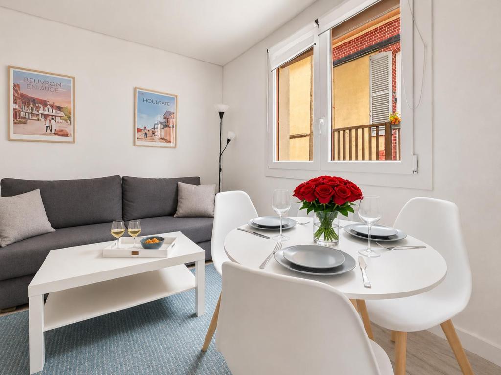 a living room with a white table and white chairs at Le Ravissant - plage et casino à 2 min, Houlgate in Houlgate