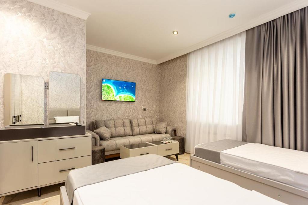 a hotel room with a bed and a couch at Şimal Hotel in Quba