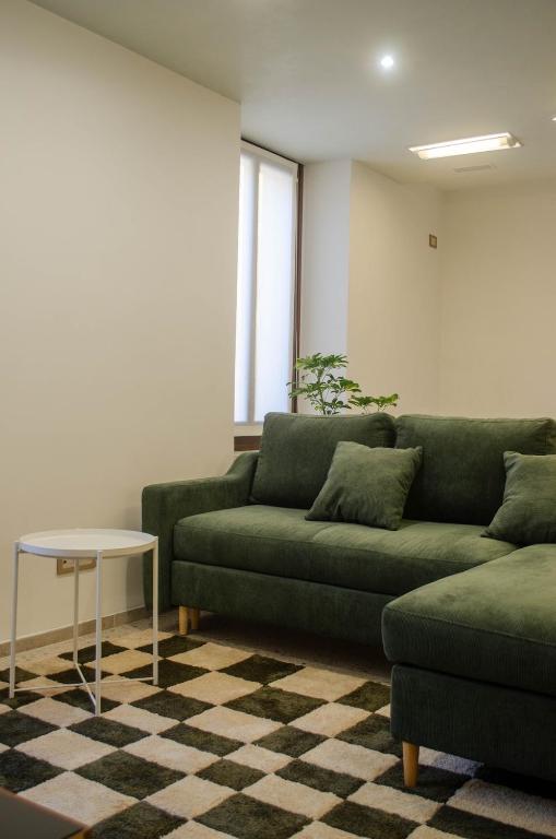 a living room with a green couch and a table at Casa Vacanze Centrale in Mori