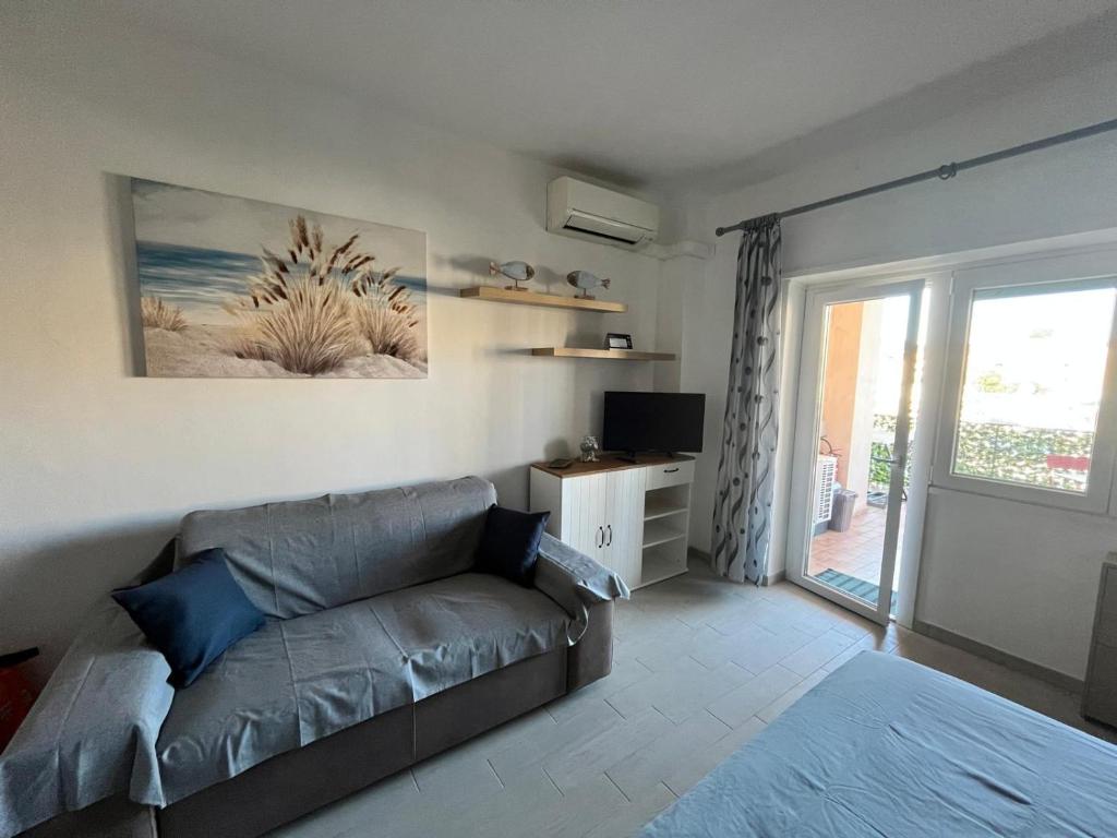 a living room with a couch and a sliding glass door at Monolocale 3 Api in Portoferraio