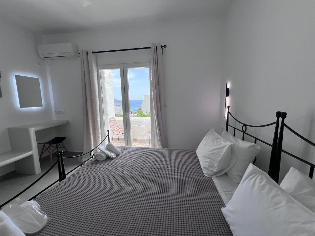 a bedroom with a bed with a view of the ocean at Danaides Studios in Batsi