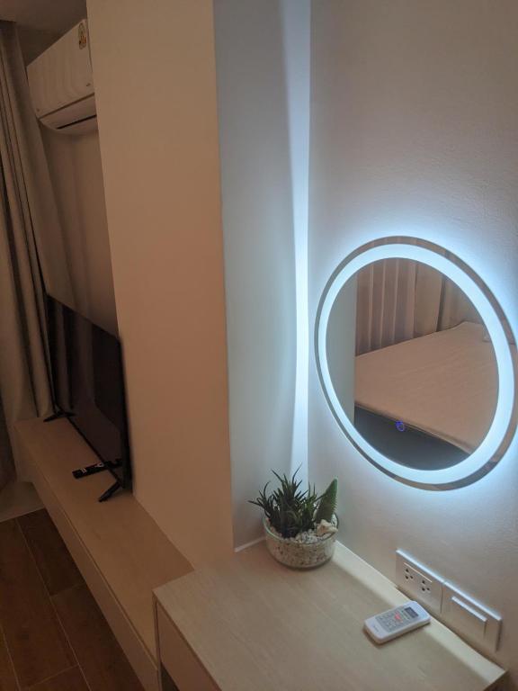 a room with a mirror and a table with a tv at Fantasea Condo Kamala 1bdr in Kamala Beach