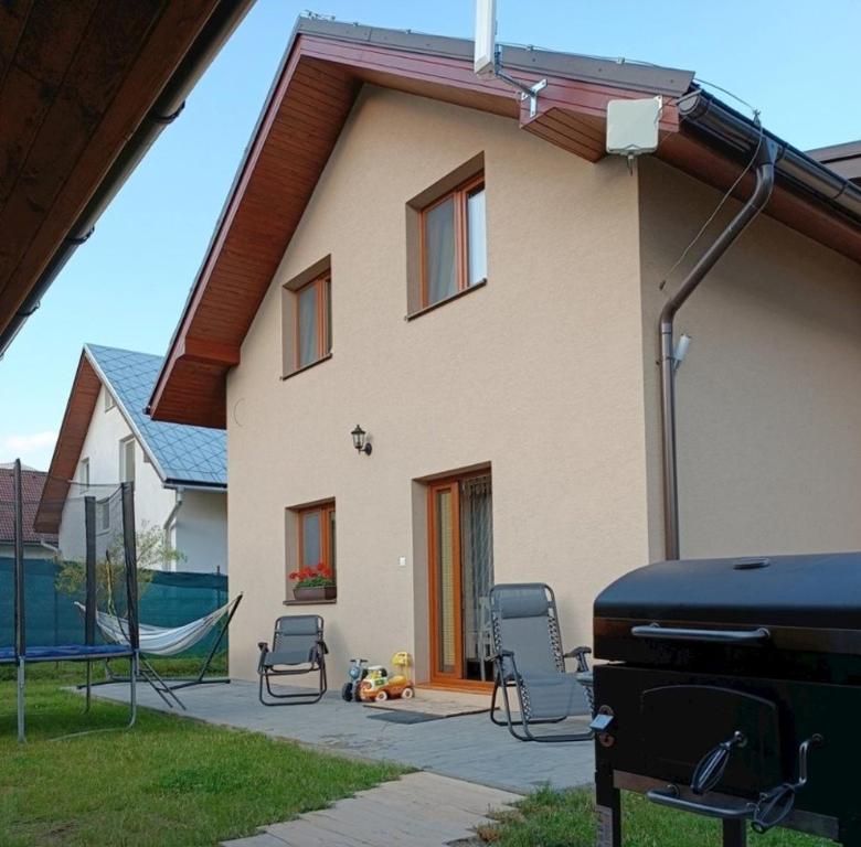 a house with chairs and a hammock in front of it at Chalupa Chotár in Terchová
