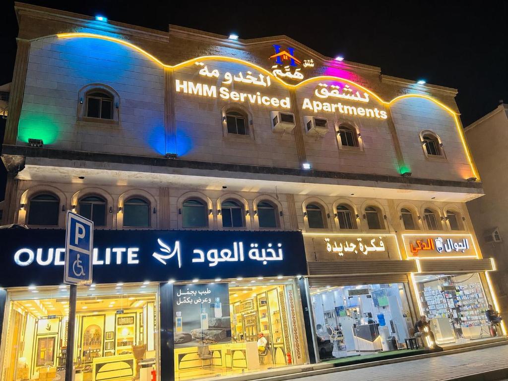 a building with a street sign in front of a store at Hmm Serviced Apartments in Al Kura