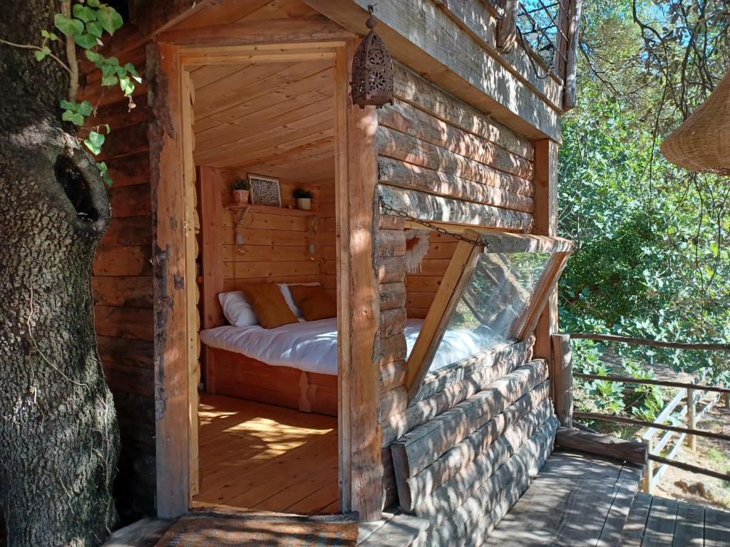 a wooden cabin with a bed inside of it at Brescou Lodges in Murviel
