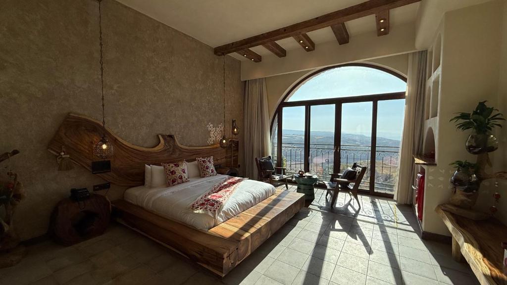 ein Schlafzimmer mit einem großen Bett und einem großen Fenster in der Unterkunft Tal Rumman Boutique Hotel in Gerasa