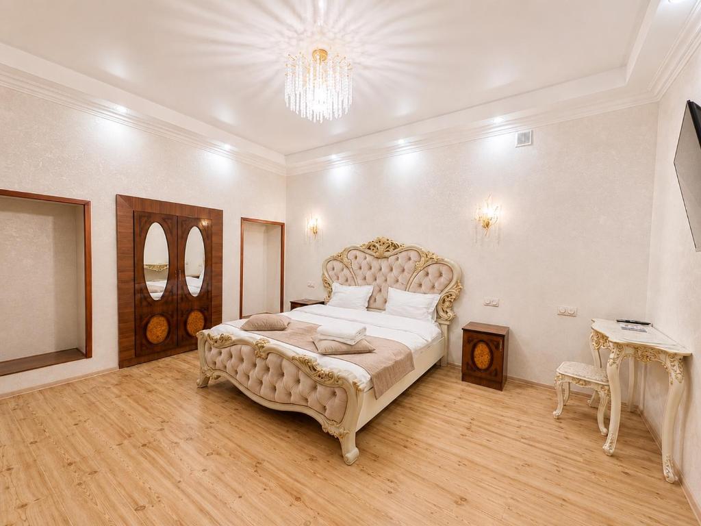 a large bedroom with a large bed with a chandelier at Old Yerevan by IGIT in Yerevan