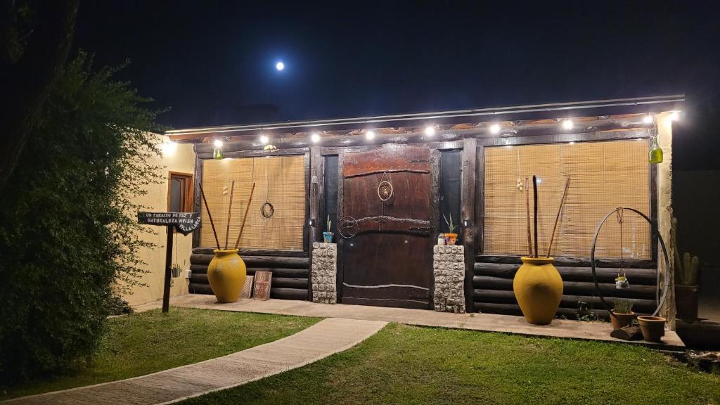 two large vases sitting in front of a building at night at Namasté in Villa Larca