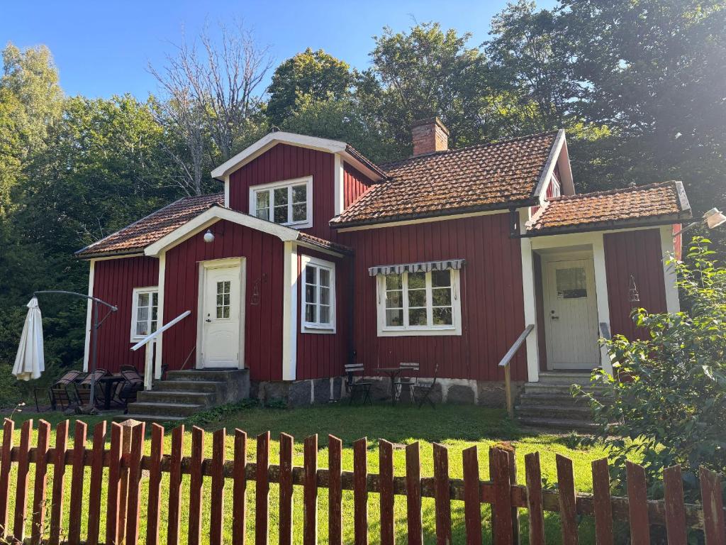 a red house with a fence in front of it at Hus Bokhultet in Ruda