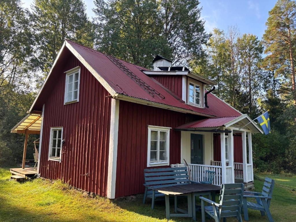 a red house with a picnic table in front of it at Hus Blommekulla in Högsby