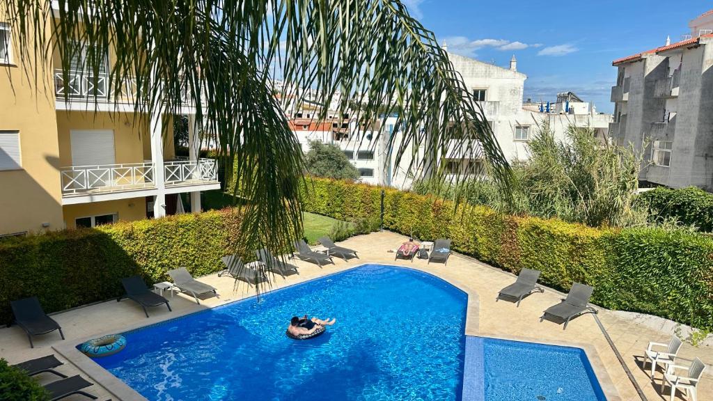 a person laying in a raft in a swimming pool at Garden Hill M - Shared Pool - 6 Guests - Albufeira in Albufeira