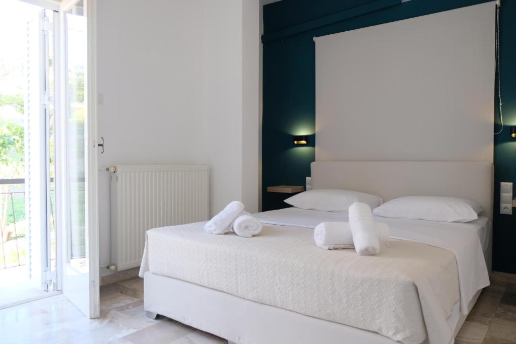 two beds in a bedroom with towels on them at Evia Blue Aura in Khrónia