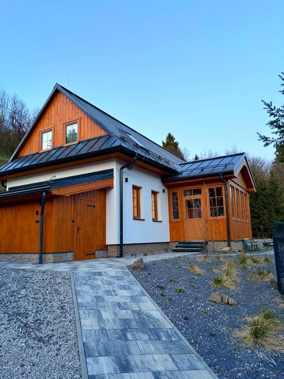 a house with a gambrel roof with a garage at Chata pod Jabloňou in Banská Štiavnica