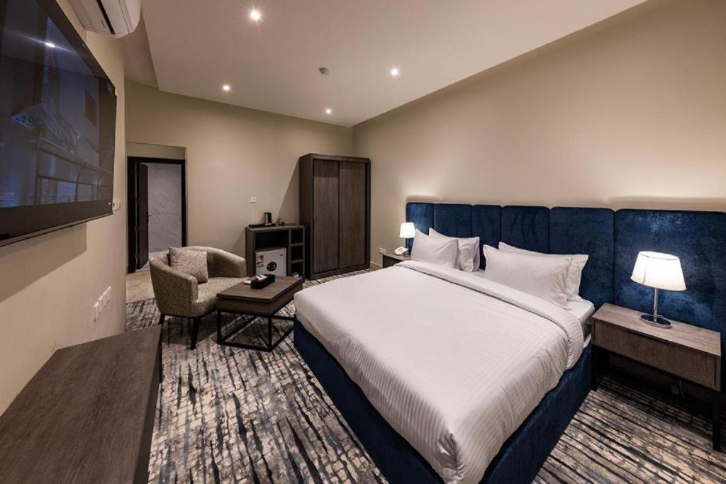 a hotel room with a large bed and a chair at Vision 2 Islamabad in Islamabad