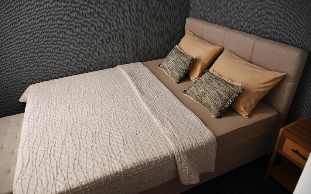 a bed with two pillows and a white blanket at Apratman Shine Kula in Kula