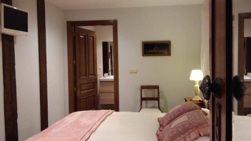 a bedroom with a bed and a television in a room at Kapel Etxea in Urzainqui