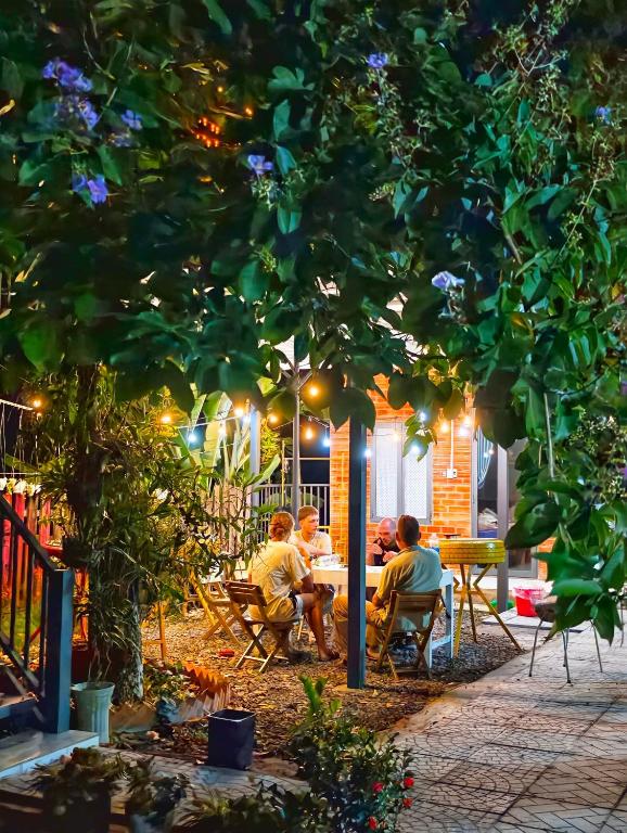 a group of people sitting at a table under a tree at Cat Tien Backpackers Hostel in Cat Tien