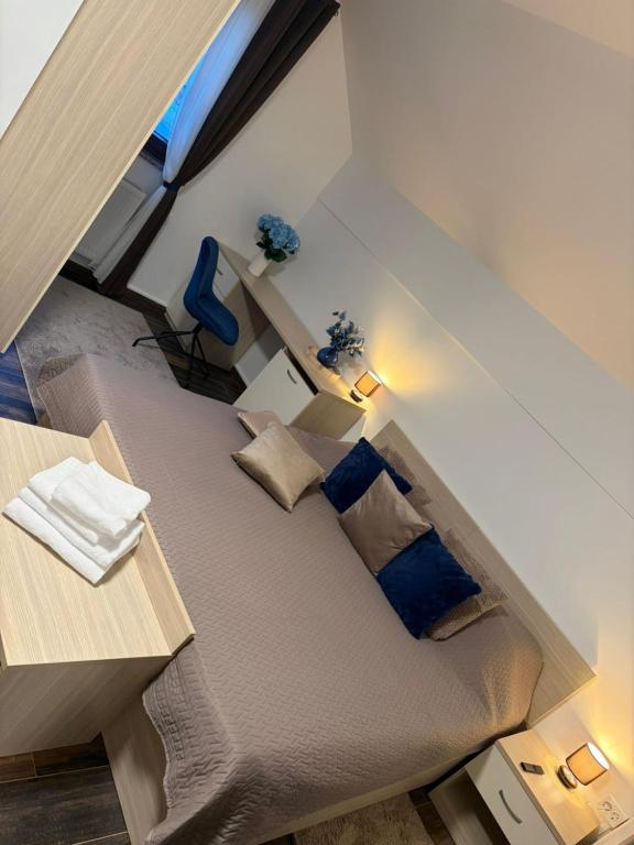 a room with a large bed with blue pillows at Croatia Palace - Ravna Gora in Ravna Gora