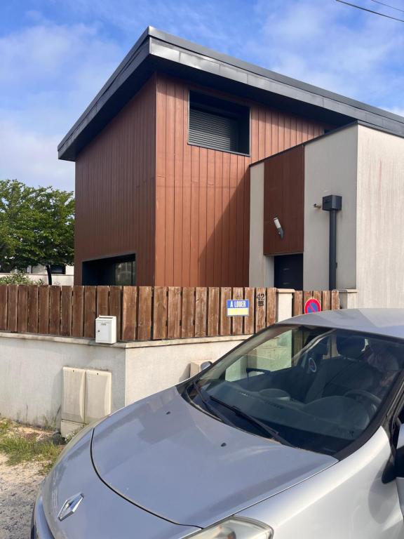 a car parked in front of a building at Maison classée à 100m de l'océan in Mimizan-Plage