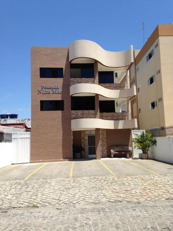 un edificio con un estacionamiento delante de él en Pousada Nilza Mar, en Maceió