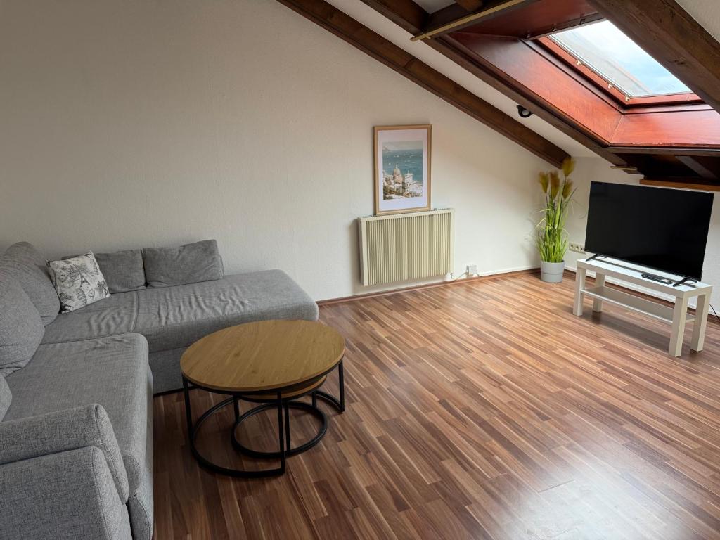 a living room with a couch and a table at Cozy Attic in Berkach