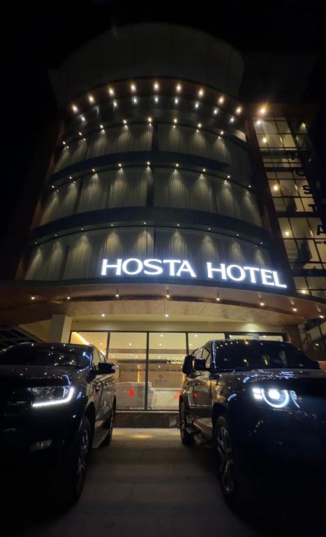 a hotel with two cars parked in front of it at Hosta Inn Hotel and Resort in Edappāl