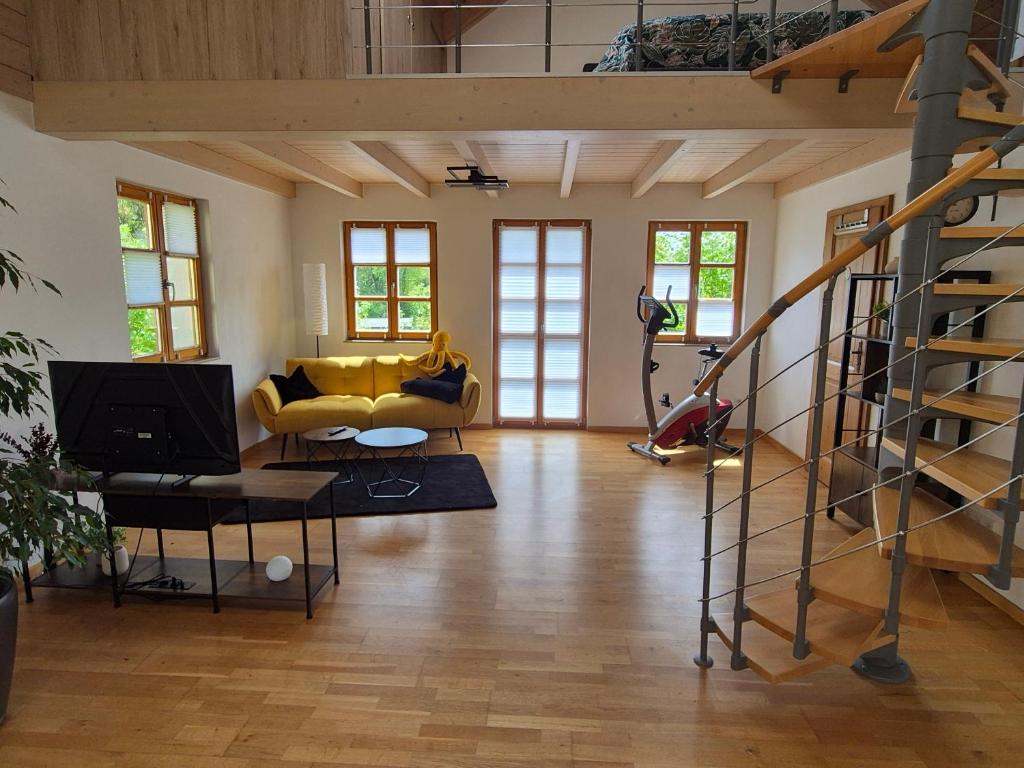 a living room with a yellow couch and a staircase at LIV Retreat in Dietenhofen