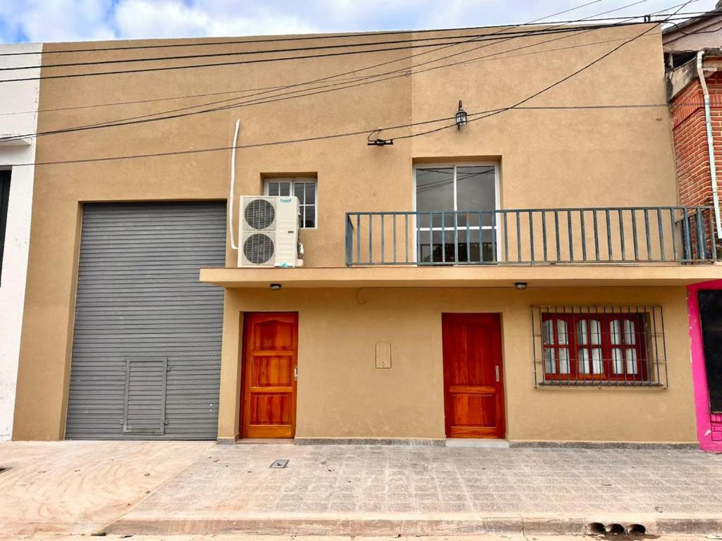 a house with two garage doors and a balcony at Apart Boutique EL DESCANSO in Libertador General San Martín