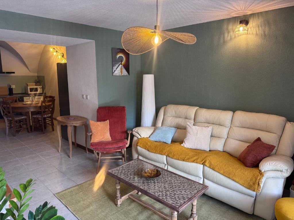 a living room with a couch and a table at Le Secret d'Adèle in Chateauroux-les-Alpes