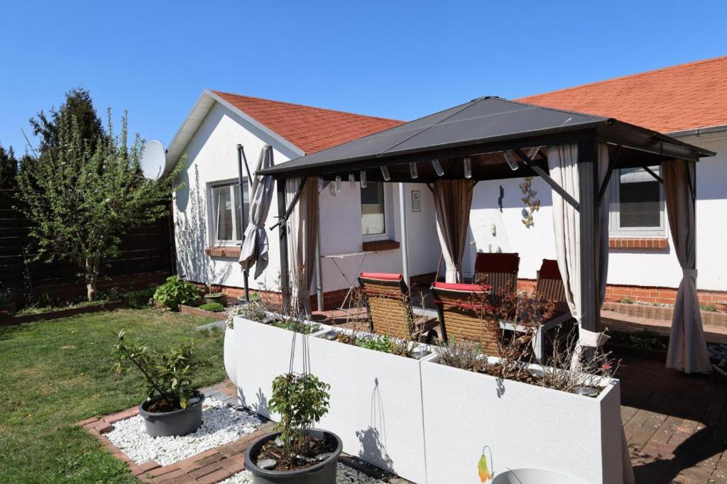 a patio with a black umbrella on a house at Ferienbungalow Meerjungfrau im Seebad Ueckermünde in Ueckermünde