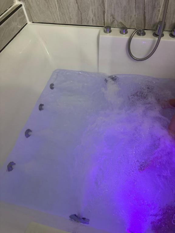 a bath tub filled with purple water in a bathroom at Studio with jacuzzi near Atlantic ocean in Myrtle Beach