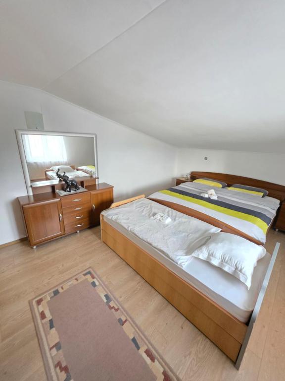 ein Schlafzimmer mit einem Bett, einer Kommode und einem Spiegel in der Unterkunft Lily 2 in Ljubuški