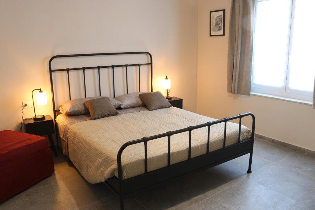 a bedroom with a large bed with two lamps at Casa Vacanza del Palio 2 in Nizza Monferrato