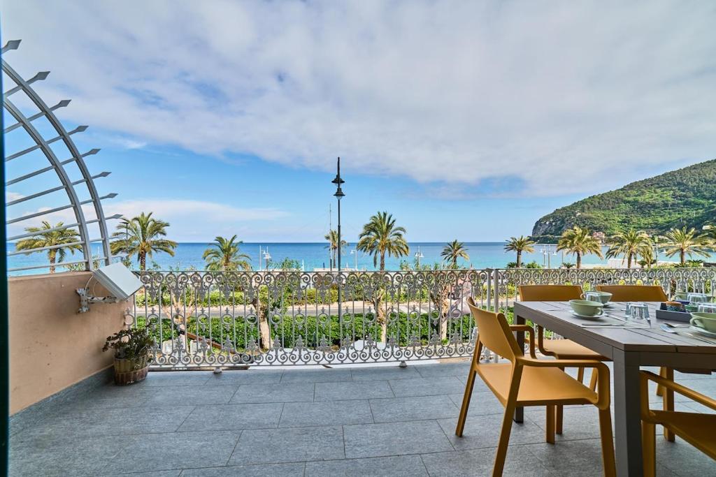 a patio with a table and chairs and the ocean at Doretta's House - Luxury Apartment in Noli