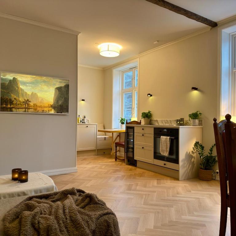 a living room with a kitchen and a table at Oslo, Classic Apartment in Oslo
