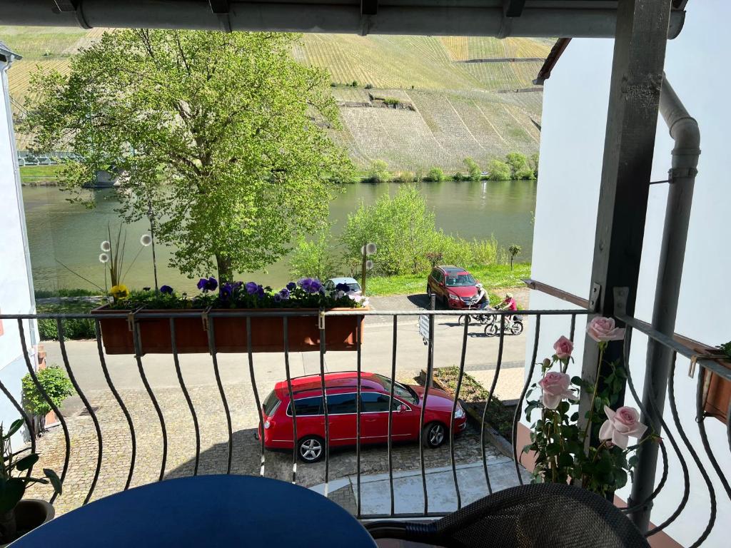 a red car parked on a balcony with a view of a river at Ferienwohnung 2 in Bernkastel-Kues