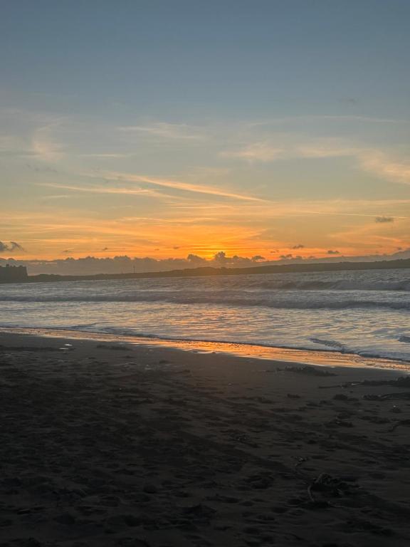 a sunset on a beach with the ocean at Glenmore in Doonbeg