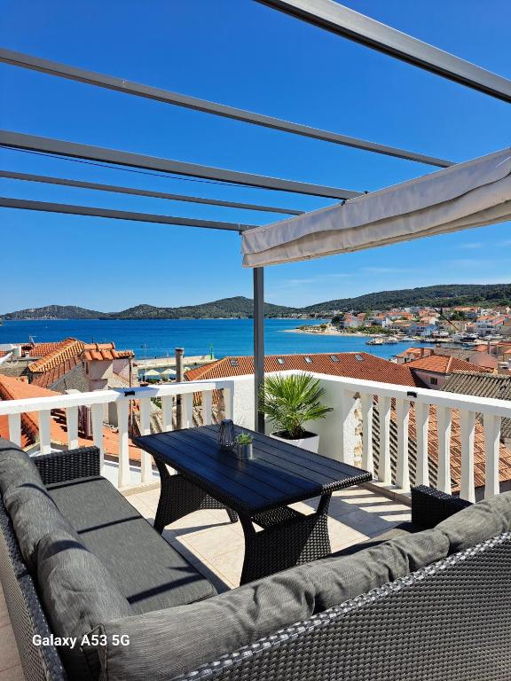 a patio with a table and chairs on a balcony at Kuća Get in Betina