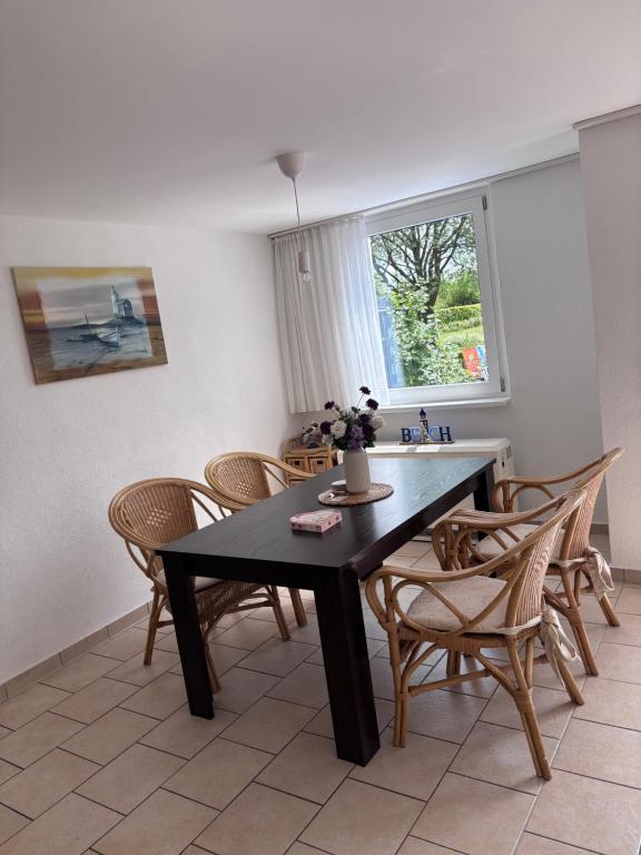 a dining room with a black table and chairs at Strandkorb 115 in Rostock