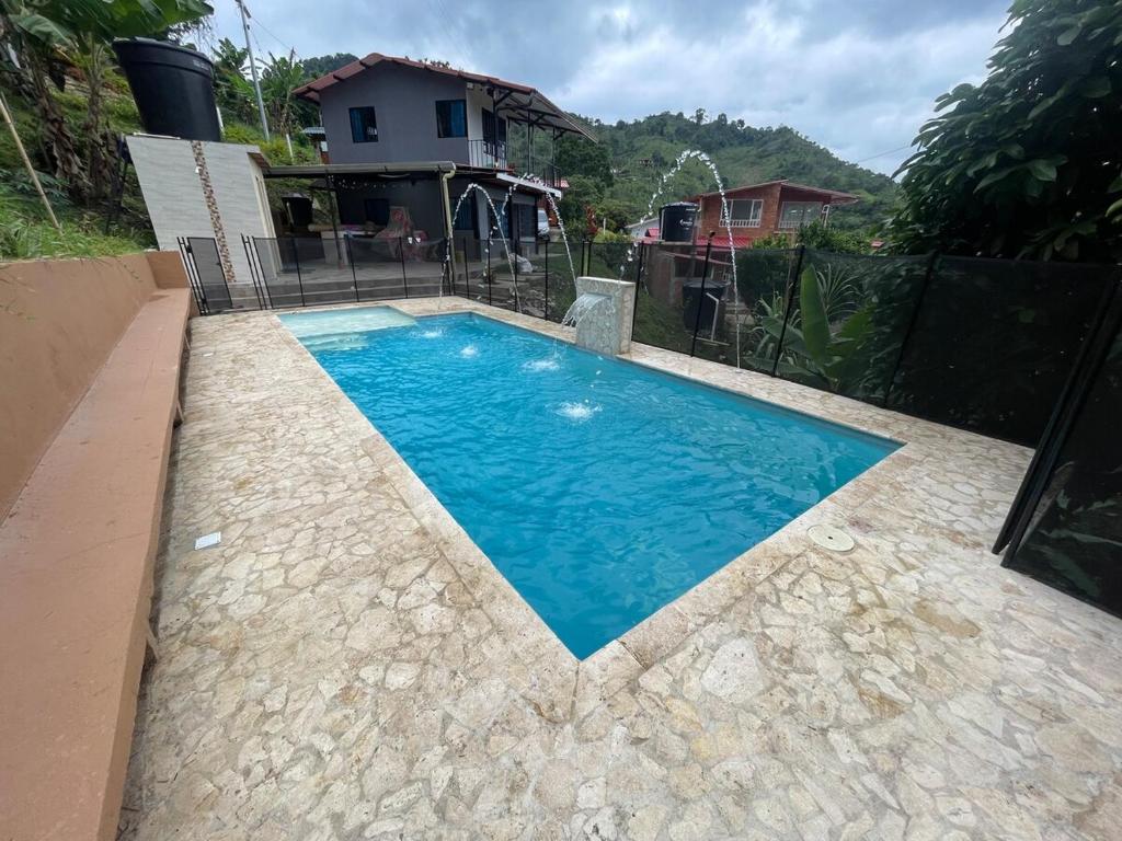 a swimming pool in front of a house at Casa campestre Shalom in Vergara