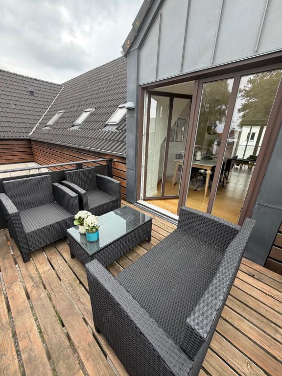 a patio with two chairs and a table on a deck at Kystvejen 40F in Hadsund