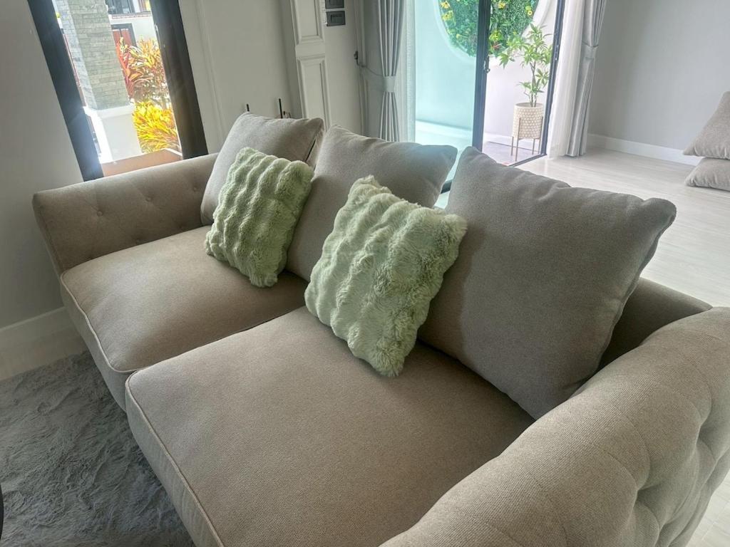 a couch with two pillows on it in a living room at บ้านแสนสุข Hun Hin in Hua Hin