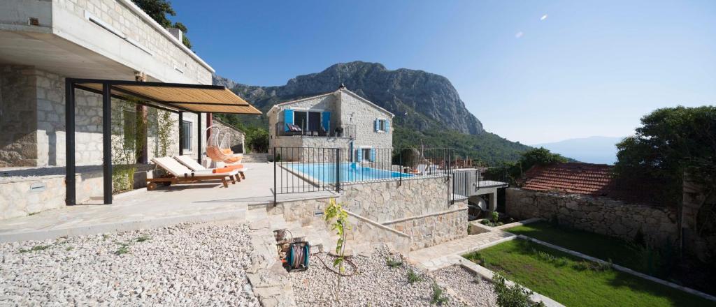 a house with a swimming pool on the side of it at Villa Jatica in Zaostrog