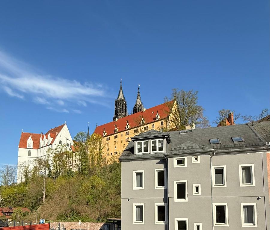 a building with a castle in the background at Panorama Apartments an der Seilbahn unterhalb der Albrechtsburg - Parkplatz und Wi-Fi - FREE in Meißen